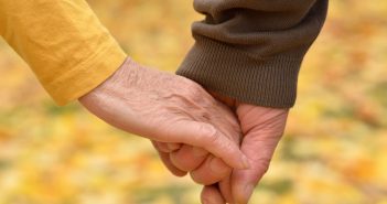elderly couple holding hands image