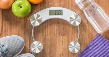 Weighing scale with fruits, grey shoes and bottled water