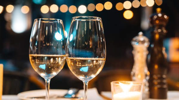 2 wine glass with white wine in the table