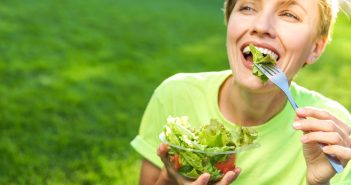 smiling woman eating salad
