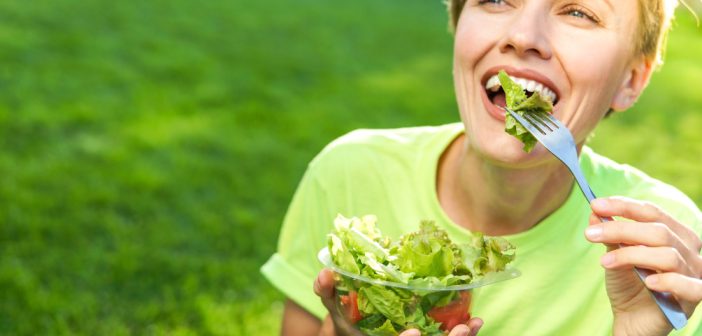 smiling woman eating salad