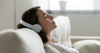 Woman lying on the couch and listening to music