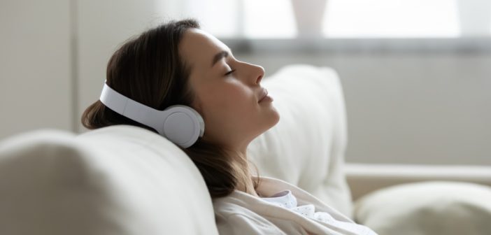 Woman lying on the couch and listening to music