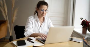 Woman with glasses working in her laptop