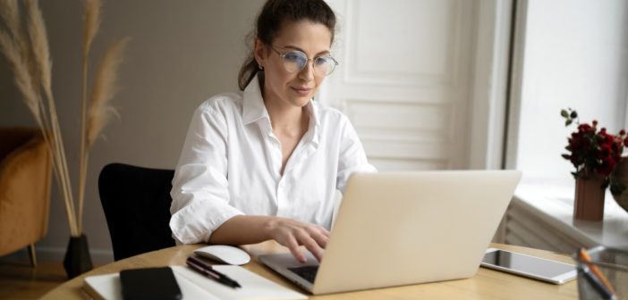 Woman with glasses working in her laptop