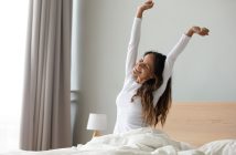 Happy woman in white stretching