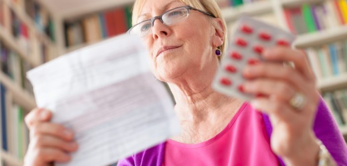 Woman with medicine and reading drug prescription